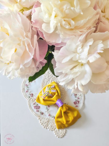 Yellow velvet bow with lilac Gemini symbol and lavender embroidered and soft lilac center.