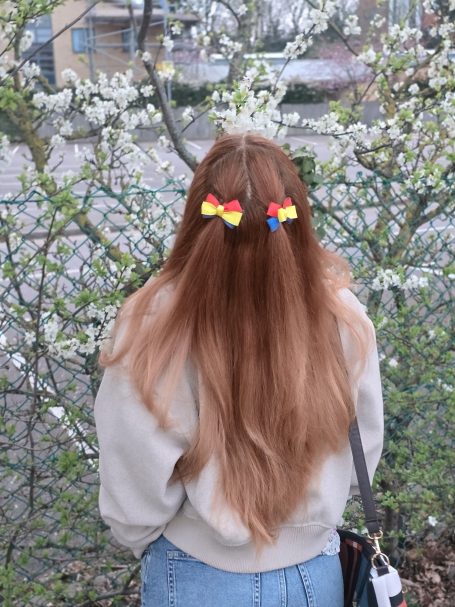 Girl wearing handmade mini bow set inspired by the Romanian flag (in blue, yellow and red).