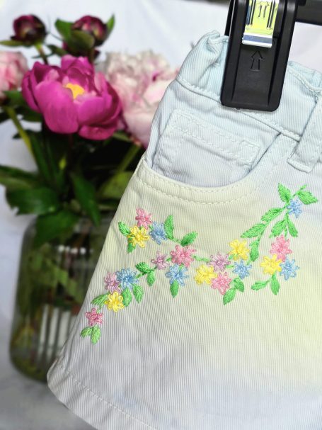 Denim shorts for 2-3 year-old girls with pastel floral embroidery.