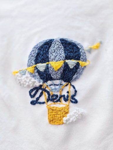 Denis' Sky - Peronalised Bodysuit for Baby Boy A soft white bodysuit, personalised with name and hand-embroidered air balloon