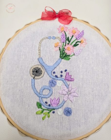 Embroidered stethoscope intertwined with flowers and decorative elements.