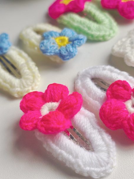 Assorted crochet hair clips featuring colourful flower designs.