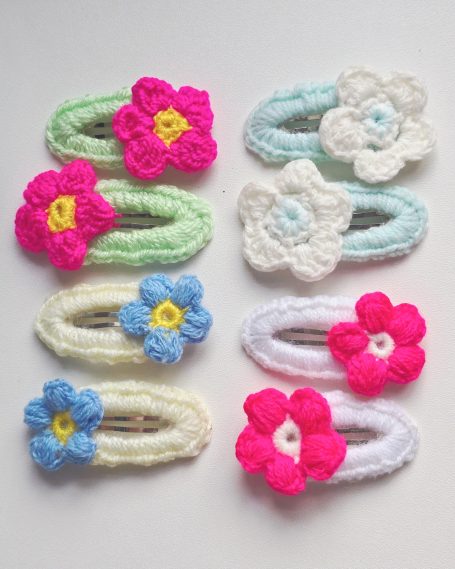 Assorted crochet hair clips featuring colourful flower designs.