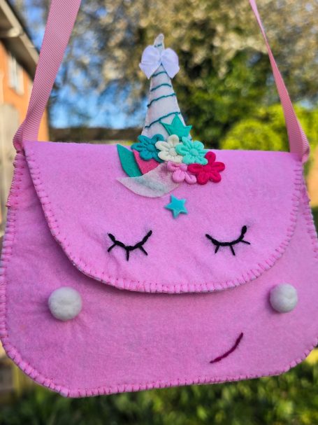 Pink unicorn-themed handbag with decorative flowers and a whimsical horn.