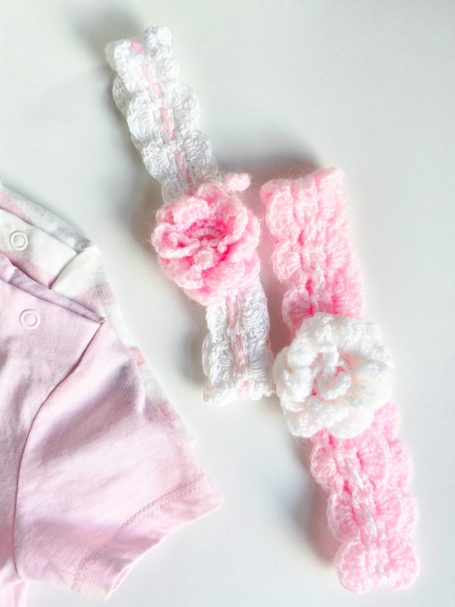 Two decorative hairbands in pink and white, featuring floral designs.