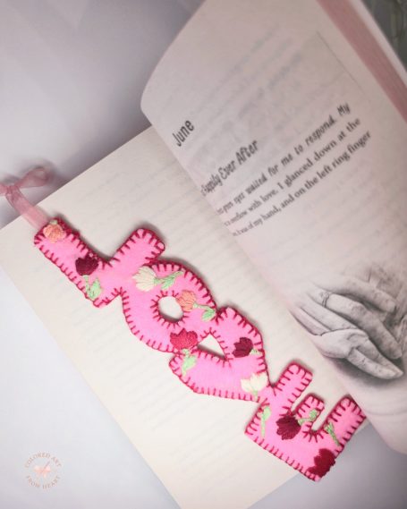 Pink felt bookmark spelling "love", with floral embroidery.