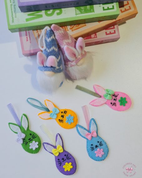 Collection of five colourful felt bunny charms in pastel colours with bows and floral details.