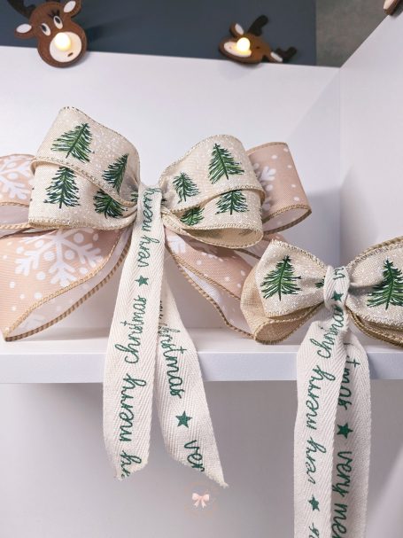 Two decorative matchy bows with green tree designs and "Merry Christmas" ribbons.