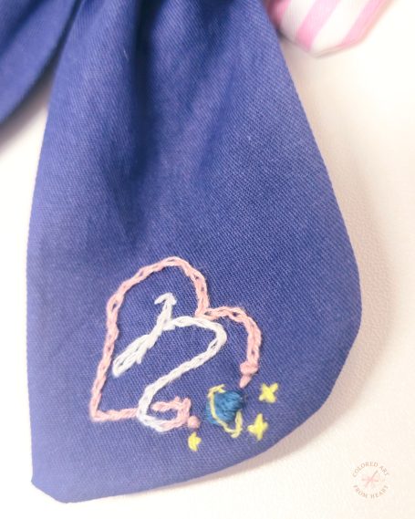 Navy blue zodiac-inspired signature bow featuring embroidered Capricorn constellation and celestial details.