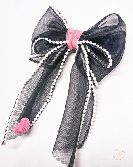Hairmade black statement hair bow with pink centre, pearl details and long ribbon tails