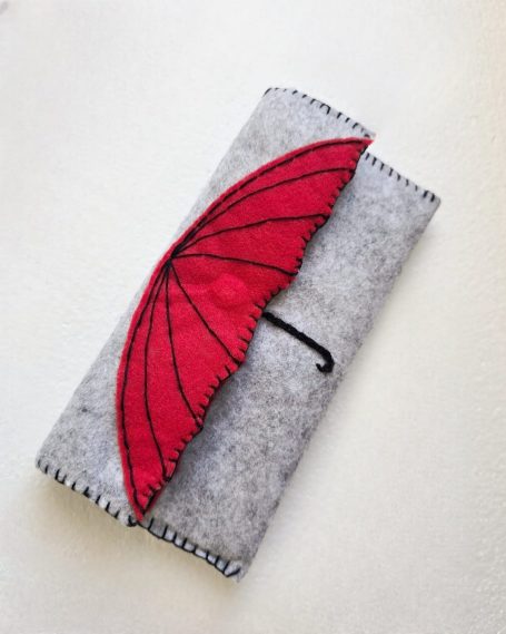 Grey pouch with a red umbrella design on the front.