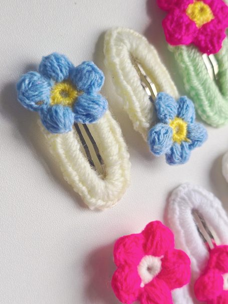 Assorted crochet hair clips featuring colourful flower designs.