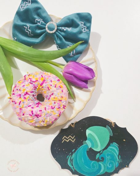 Handmade bow in a luminous turquoise shade, with Aquarius symbol embroidered several times in lilac.