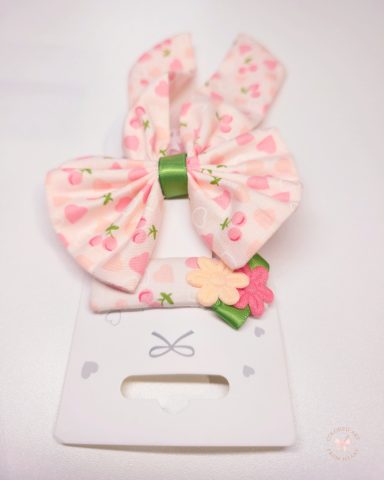 Butterfly in Love - Statement Bow and Hair Clip Set featuring a statement butterfly- bow and a matching clip. Soft pink fabric with hearts and cherry prints and a fresh touch of green.