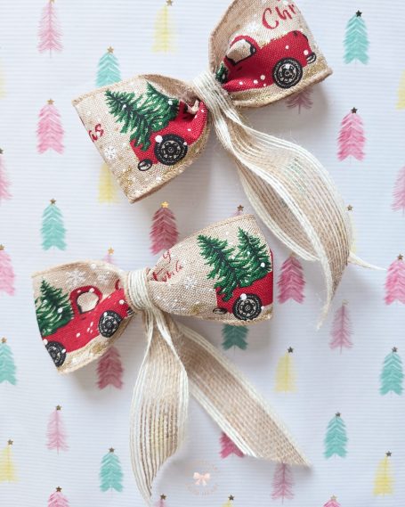 Two decorative bows featuring a red truck and Christmas trees on a patterned background.
