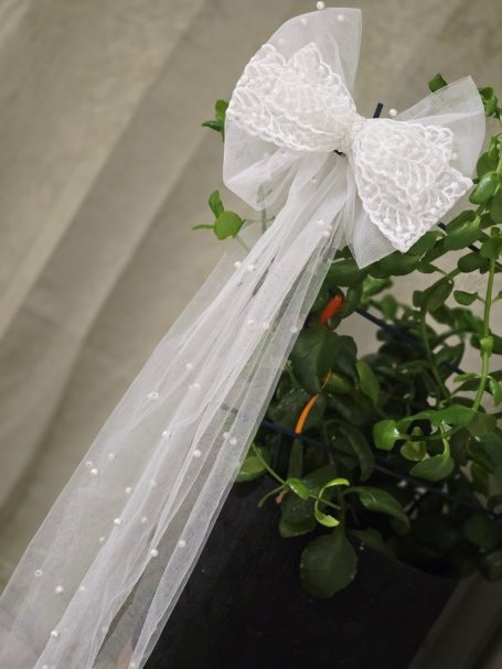 Elegant white bridal bow with long flowing tails, designed as a timeless wedding hair accesory.