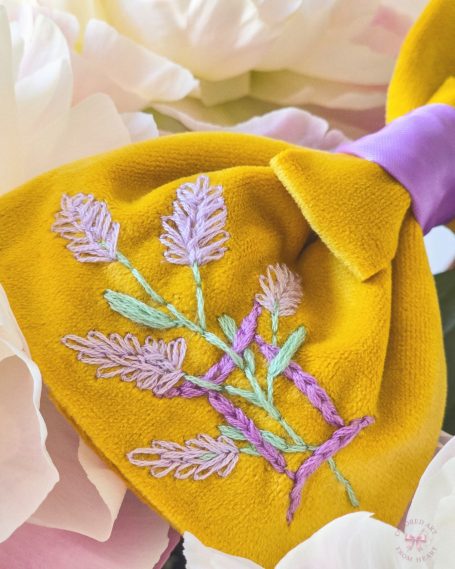 Yellow velvet bow with lilac Gemini symbol and lavender embroidered and soft lilac center.